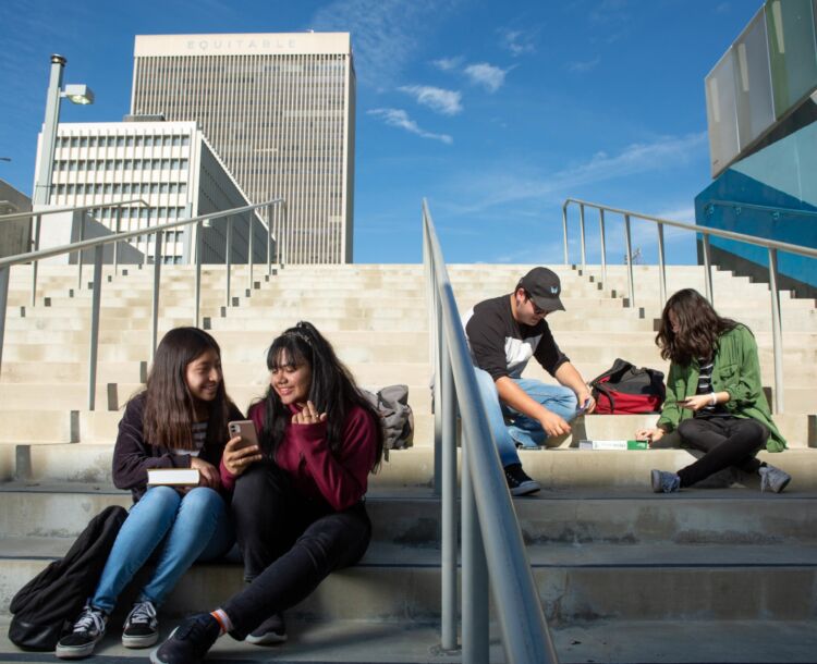 students seated on steps talking to each other